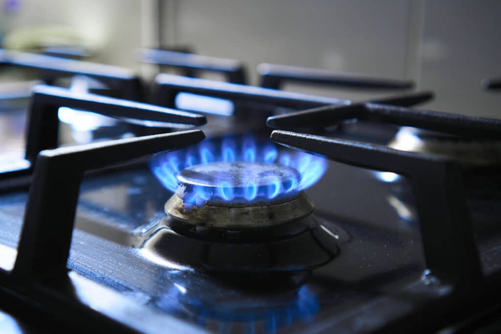 Gas stove burner with blue flame.