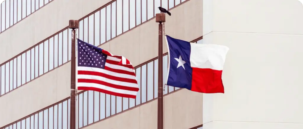Two American flags flying in front of a building