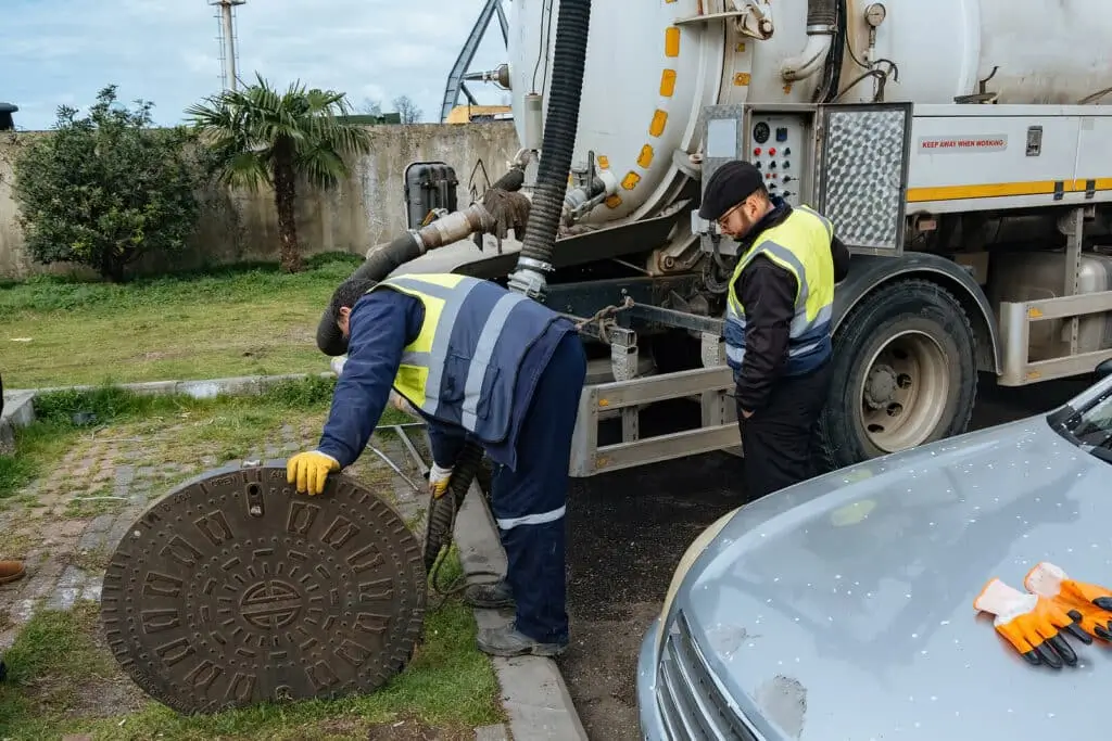Worker lifting a manhole cover outdoors
